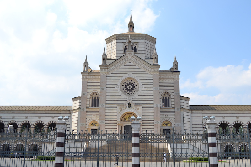 Front Famedio na Cimitero Monumentale w Mediolanie, ozdobiony dekoracyjnymi elementami, będący miejscem pamięci dla wybitnych osobistości.