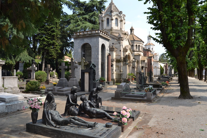 Groby na Cimitero Monumentale w Mediolanie, różnorodne w stylu i zdobieniach, stanowiące ważny element tej historycznej nekropolii.