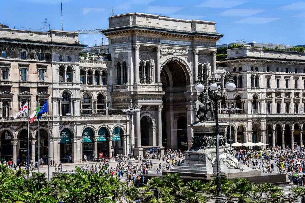 Widok na Galleria Vittorio Emanuele II z Piazza Duomo w Mediolanie, ukazujący elegancką architekturę i charakterystyczne szklane kopuły.