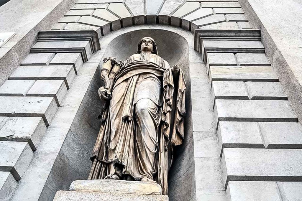 Detal architektoniczny Porta Venezia z rzeźbami i dekoracjami, ukazujący bogactwo kulturowe Mediolanu.