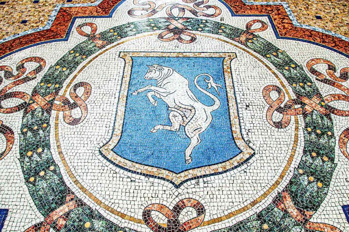 Mozaika przedstawiająca byka w Gallerii Vittorio Emanuele II w Mediolanie, symbol szczęścia i popularna atrakcja dla odwiedzających.