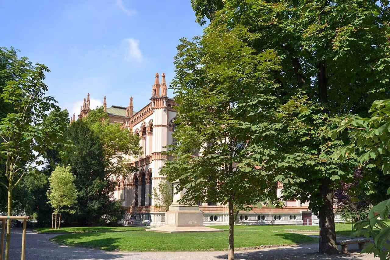 Park Giardini Pubblici Indro Montanelli w Mediolanie z Muzeum Historii Naturalnej, otoczony zielenią i alejkami spacerowymi.
