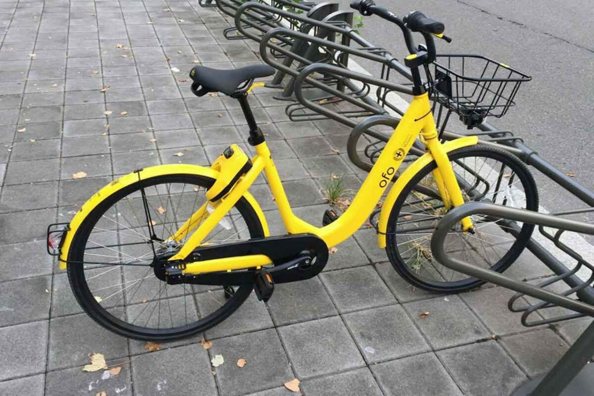 Rower Ofo na ulicach Mediolanu, element systemu rowerów miejskich, promujący ekologiczny transport w mieście.