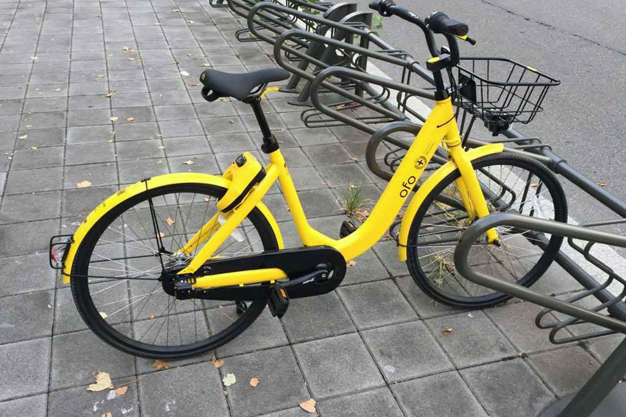 Rower Ofo na ulicach Mediolanu, element systemu rowerów miejskich, promujący ekologiczny transport w mieście.