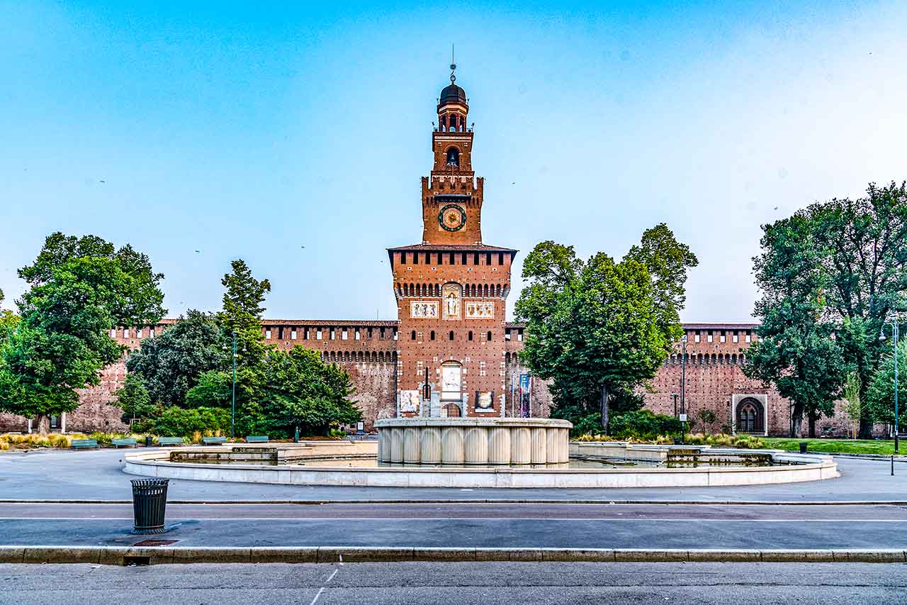 Znane miejsca w Mediolanie - piazza Castello, gdzie znajduje się Zamek Sforzów. Ożywiona atmosfera i zabytkowa architektura tworzą intrygującą scenerię.