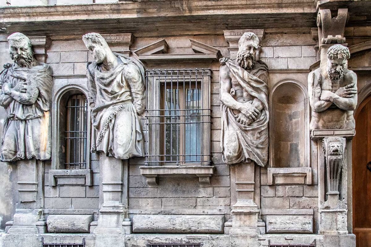 Grupa czterech telamonów po lewej stronie wejścia do Casa degli Omenoni, przedstawiających pokonanych barbarzyńców.