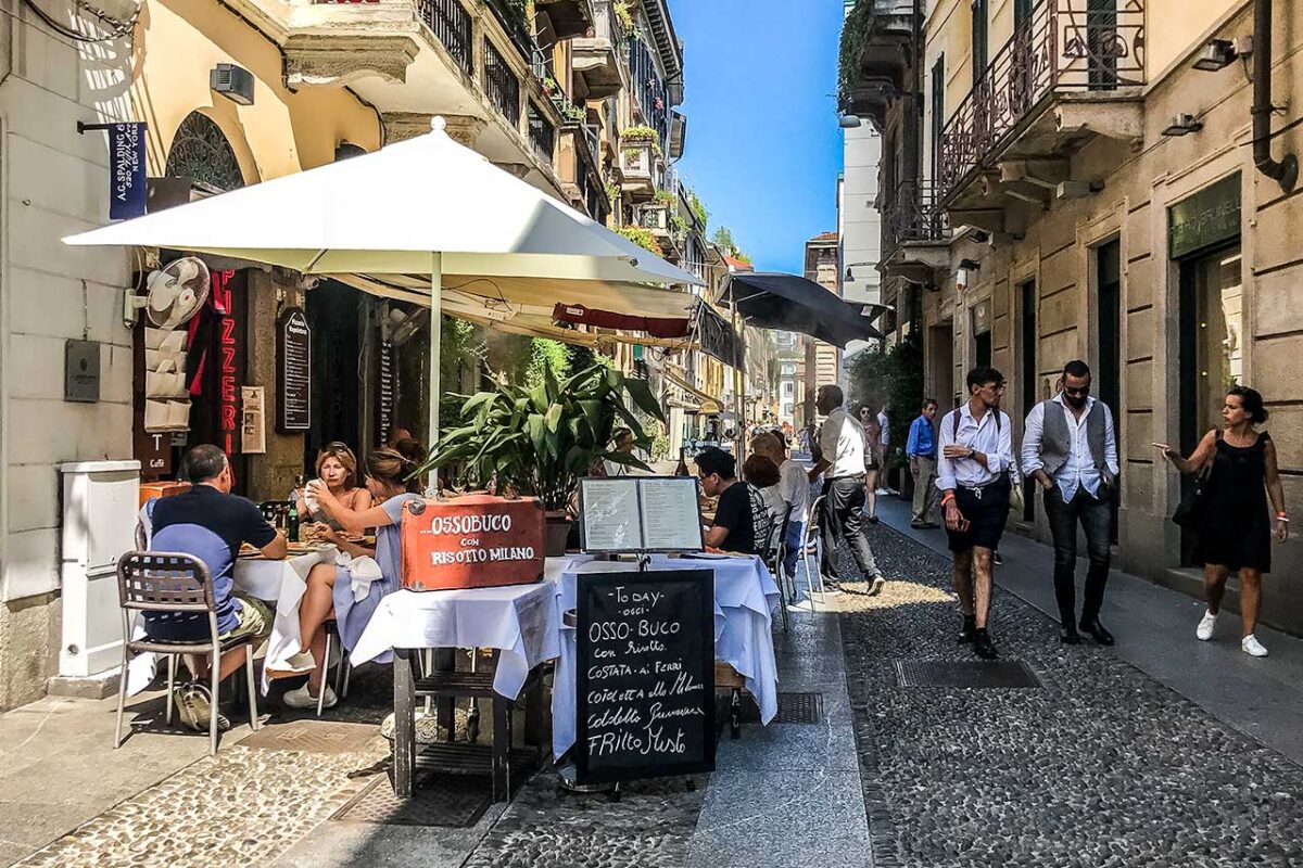 A street with restaurants and people eating at tables outside