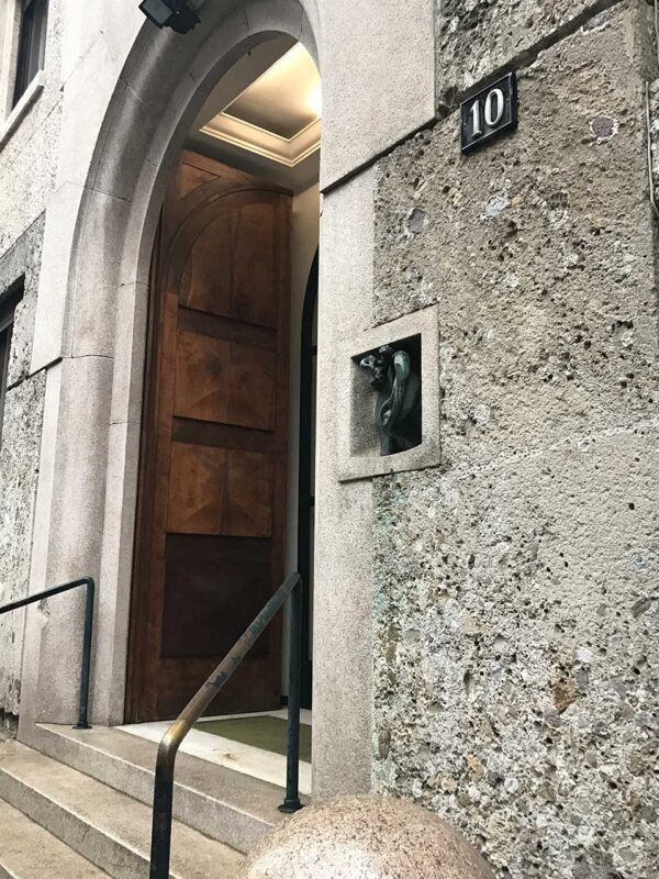 Wejście do budynku Ca’ de l’Oreggia w Mediolanie z charakterystycznym uchem na ścianie