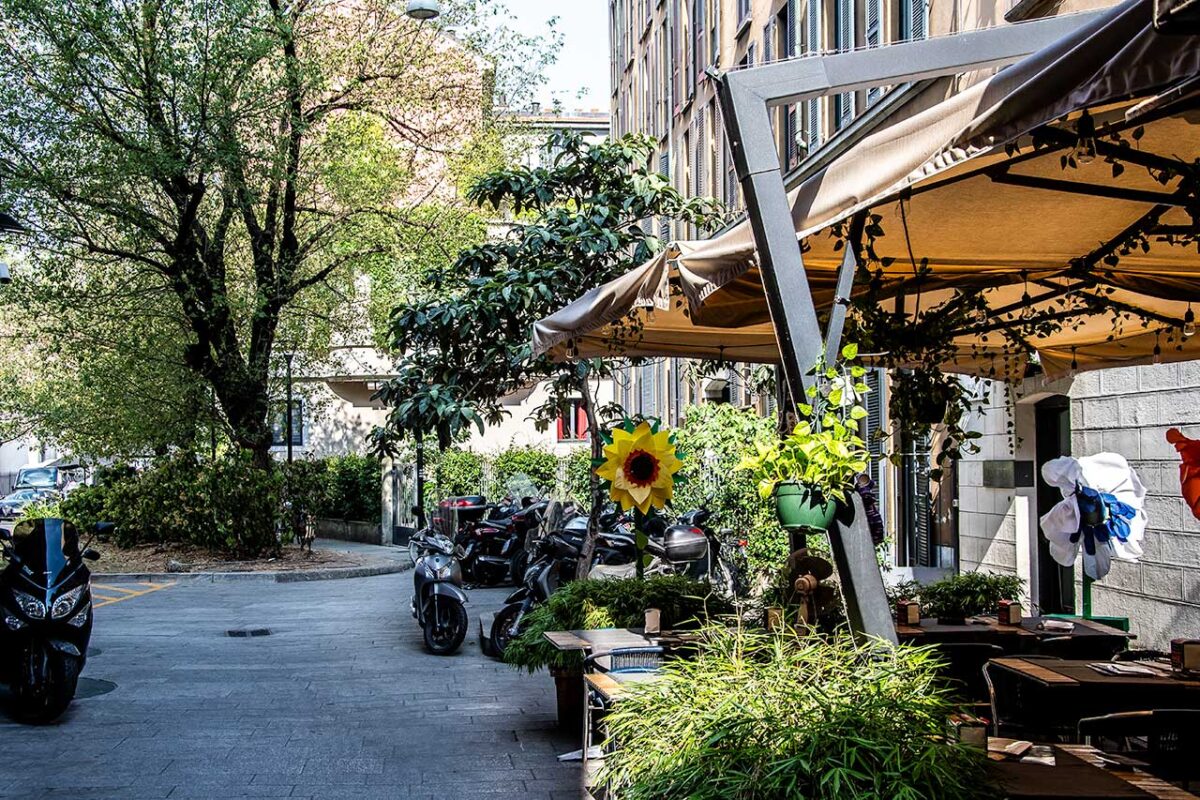 The garden of the Jamaica bar in Brera with greenery and tables