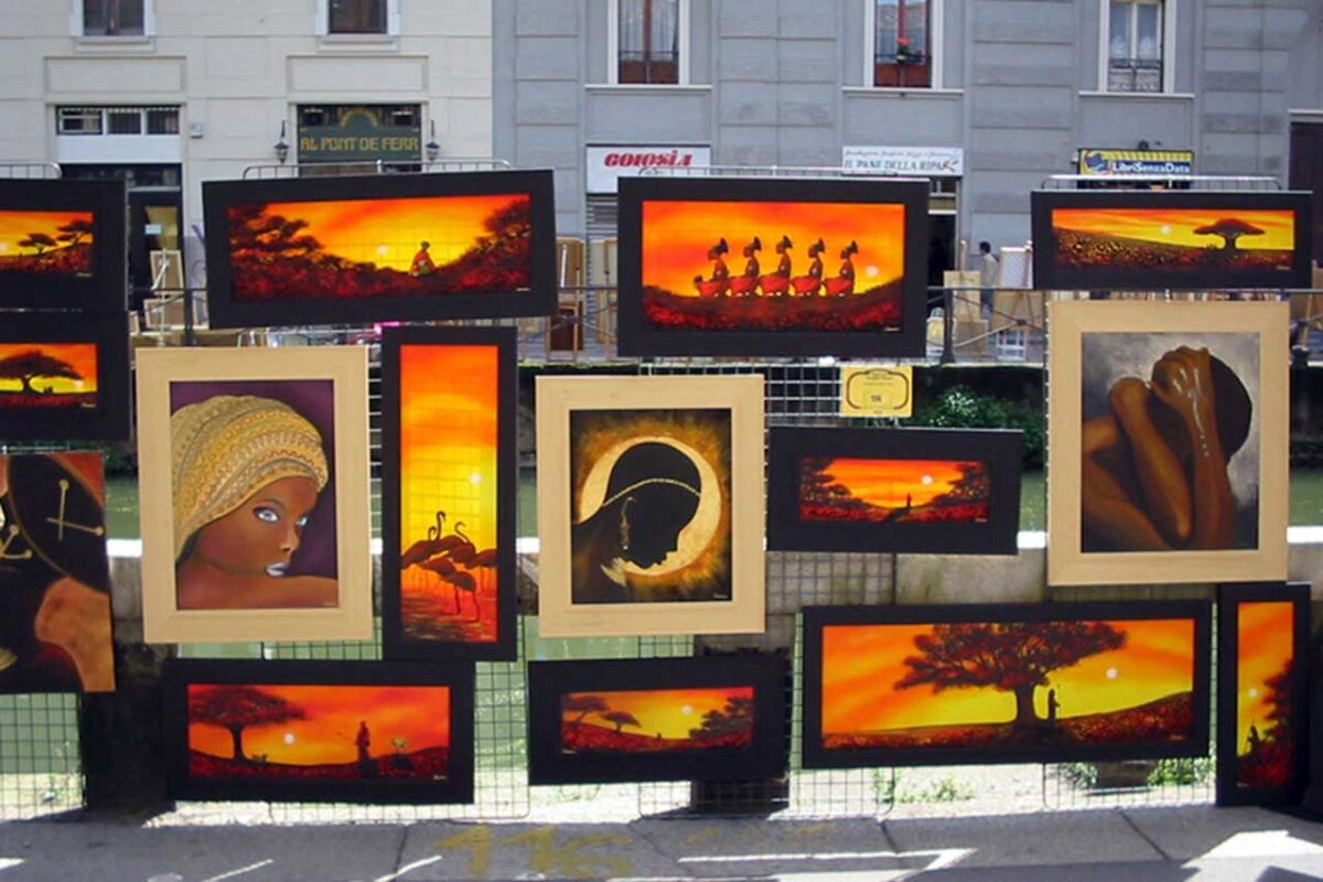 Kolorowe obrazy wystawione na ulicznej galerii przy Naviglio